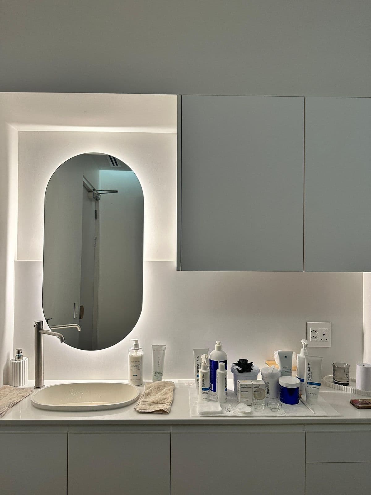 Skin & Hair Bar treatment room with skincare products and illuminated mirror.