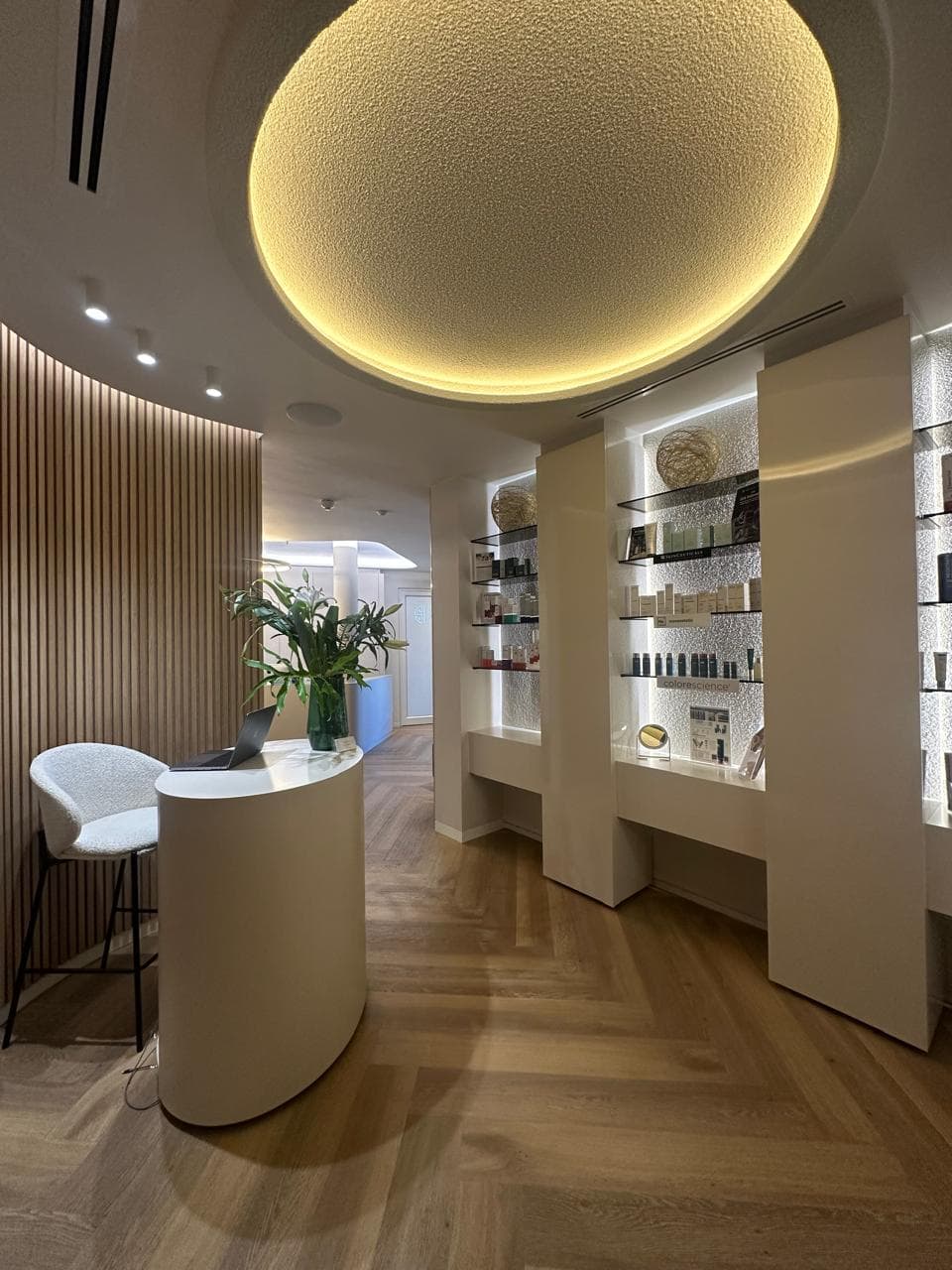 Skin & Hair Bar reception with warm lighting, product shelves and wood detailing.