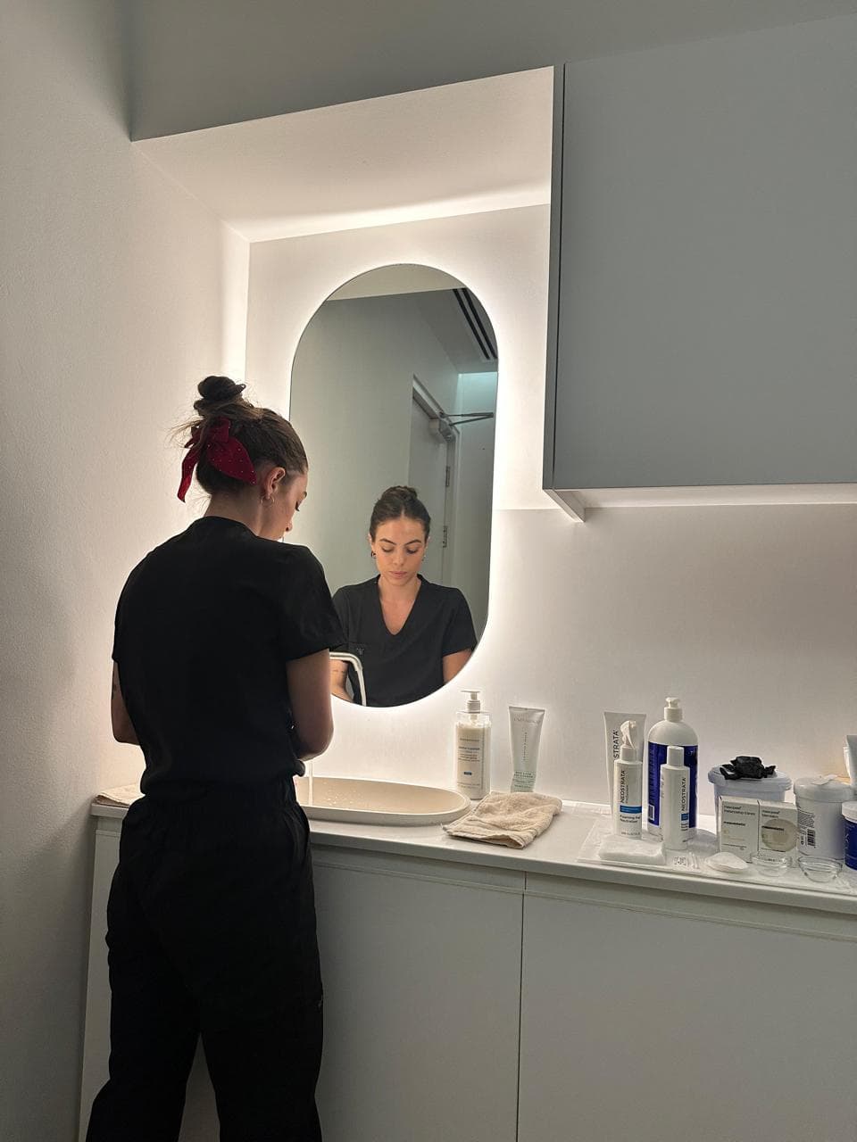 Therapist preparing skincare products in the Skin & Hair Bar treatment room.